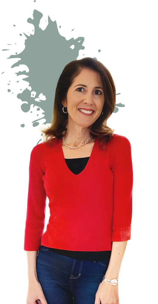 A woman in a red sweater and jeans smiles against a black background. There's a gray paint splatter behind her, adding a creative touch.