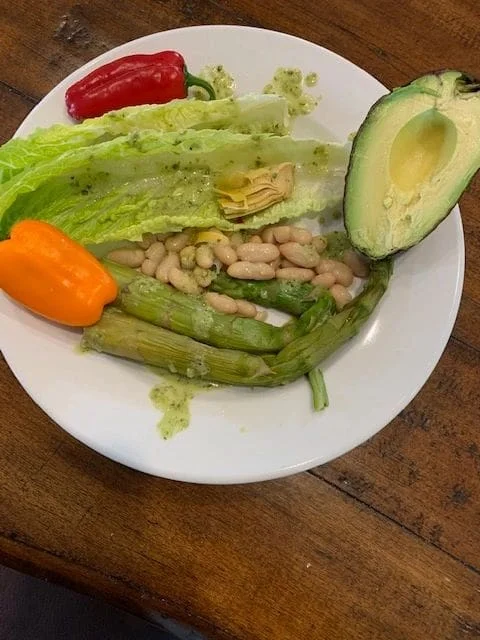eating healty featured image Plate of fresh salad ingredients: romaine lettuce, artichoke heart, white beans, grilled asparagus, avocado half, red and orange peppers. Light dressing.