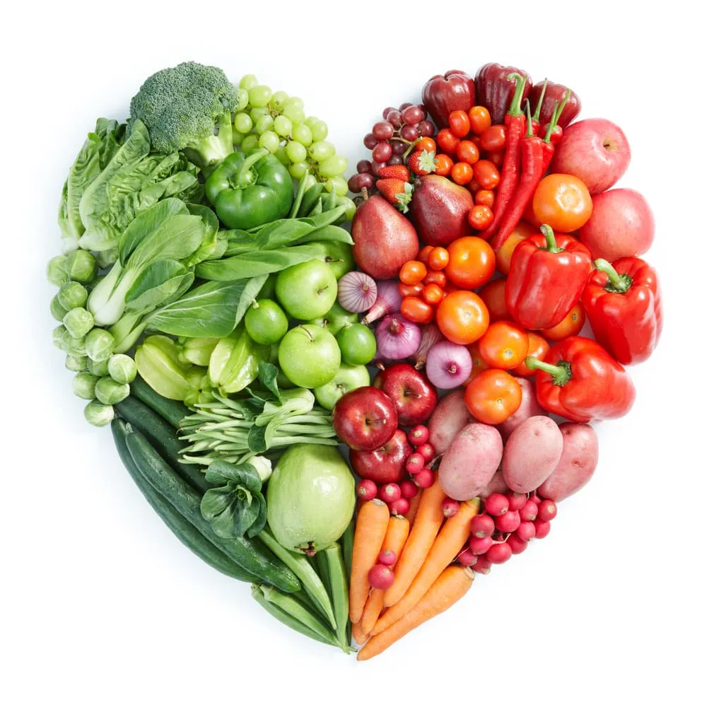 healthy-food Heart-shaped arrangement of colorful fruits and vegetables. Left half is green, with broccoli and cucumbers; right is red-orange, featuring peppers and carrots. Bright and vibrant.